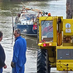 Segelboot Ylva beim Slippen mit gelbem Radlader, Person in blauer Jacke